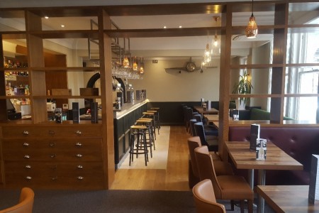 The Chequers Hotel, Newbury - wooden interior fittings including booth seating, tables, shelving and drawers 