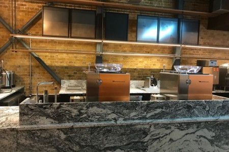 Starbucks, London Bridge - marble counter, coffee machines, exposed brickwork behind