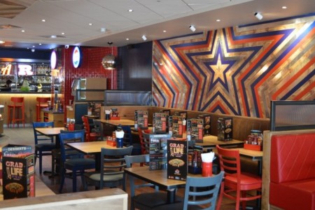 Pizza Hut, Bristol - large star motif on wall in red, silver and blue, red and blue chairs and wooden tables 