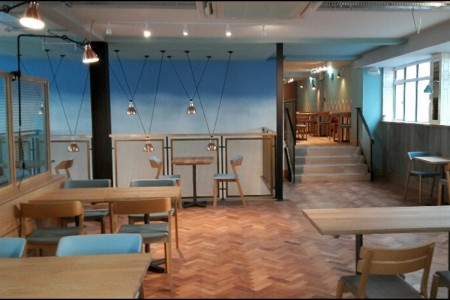 Wildwood, Bournemouth - blue walls, blue and wooden chairs and wooden tables, wooden parquet flooring