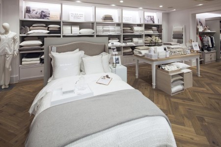 The White Company, Norwich - white bed spread with grey blanket at the foot, hardwood flooring, white decorations around