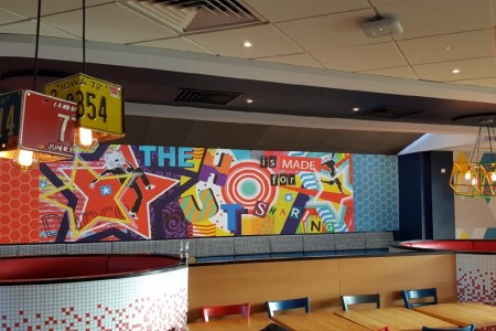 Pizza Hut, Stevenage - close up of graffiti-style wall art and American license plates hanging from the ceiling 