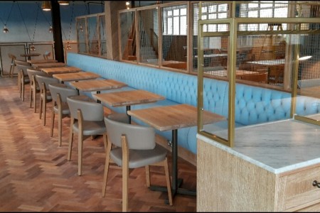 Wildwood, Bournemouth - blue bench seating with wooden tables and wooden parquet flooring