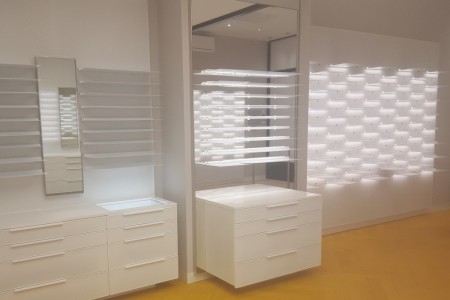 Modern white bespoke cabinets with bright lighting, by bespoke London shopfitters Oakwoods