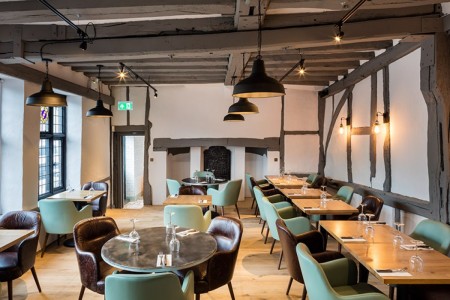 Wildwood, Crawley - green and brown leather chairs around wooden tables, white walls with beams