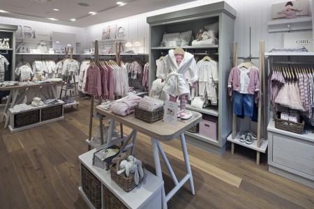 The White Company, Norwich - children's clothing area with white panelled walls and cabinets and wooden flooring