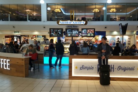 Auntie Anne's in Luton Airport with its build in brick wall sign, backlit branding and bespoke joinery counters