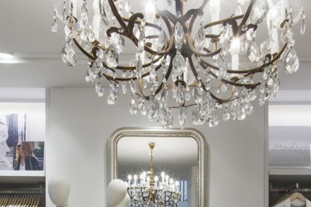 The White Company, Norwich - close up of chandelier with mirror behind reflecting chandelier 