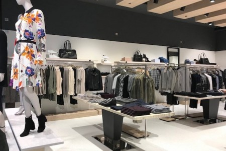 Reiss, Canary Wharf - black and white walls, shelving with clothing, display tables with clothing