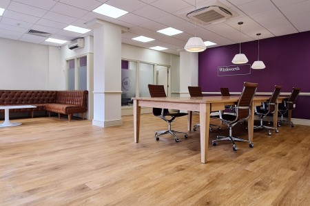 Winkworth Estate Agents, Crystal Palace - table with brown leather chairs, leather sofa and purple wall with logo 