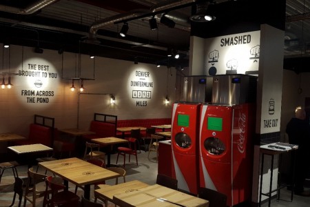 Smashburger, Dunfermline - drinks machines, wooden tables and chairs, urban graphics on white tiled walls