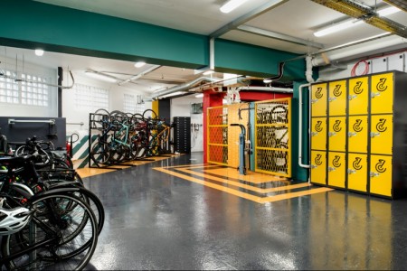 Prudential Buildings, Bristol - bike storage with teale and white walls/ceiling, with black and orange floor graphics and yellow lockers