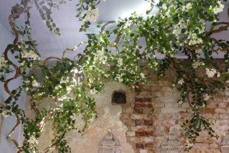 Megan's, Wimbledon - exposed brickwork wall and branches with artificial leaves and flowers
