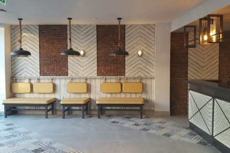 Prezzo, Epsom - seating area next to bar with brick and wooden cladding on wall