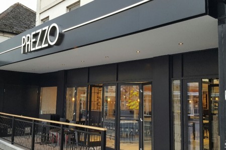 Prezzo, Chippenham - exterior with black shopfront and white lit up logo