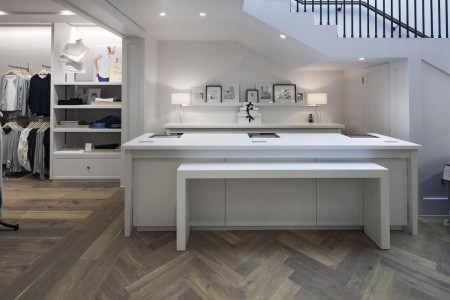 The White Company, Norwich - till area with white desks, white walls and parquet flooring