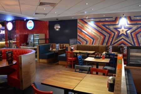 Pizza Hut, Bristol - wooden tables, blue and red chairs, blue and red sofas and red, silver and blue star motif in background 