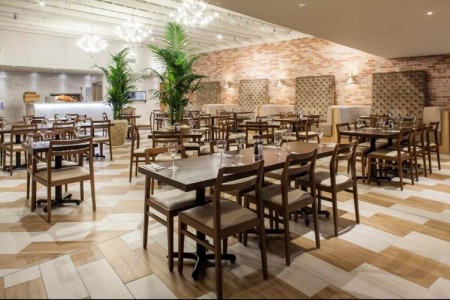 Prezzo, Abergavenny - large potted trees, dark wooden tables and chairs, brown tiled walls, wooden floor, bright lighting