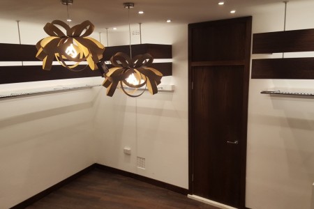 NorieM, London - unique 'bow' looking light fittings with dark wood door and shelving behind