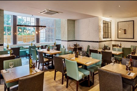 Wildwood, Crawley - blue and brown leather seats around wooden tables, white painted brickwork and wooden floor