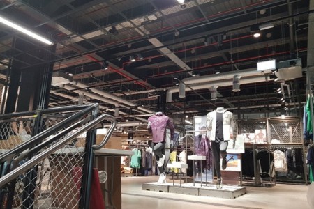 Interior of Adidas shop with bespoke fittings, staircase, clothing racks