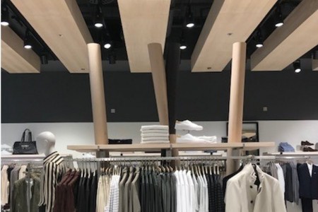 Reiss, Canary Wharf - wooden details in ceiling with lighting, clothing displays below