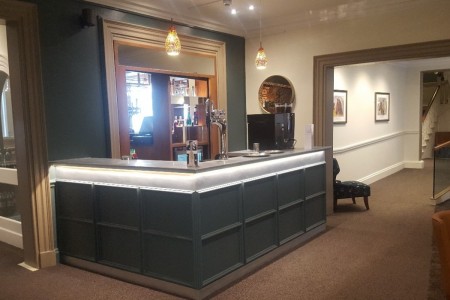 The Chequers Hotel, Newbury - small bar area with blue panelling around bar and backlit