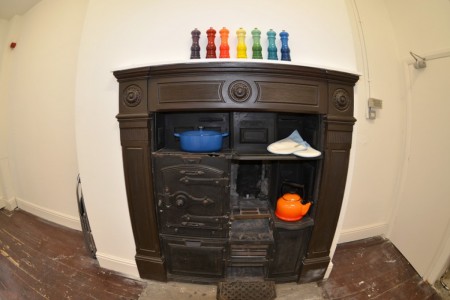 Le Creuset, Leeds - fireplace surround with Aga and colourful pepper mills