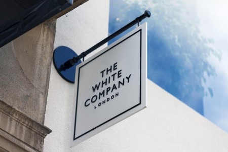 The White Company, Norwich - hanging sign on outside of building with name and logo