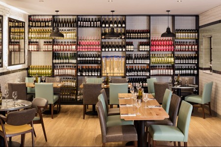 Wildwood, Crawley - large shelving area filled with wine bottles behind a seating area